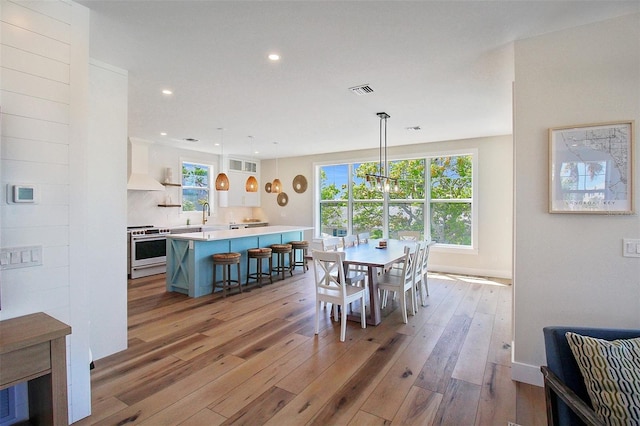 dining area with light hardwood / wood-style floors, a chandelier, and a wealth of natural light