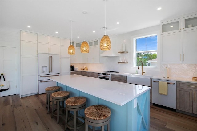 kitchen featuring white cabinetry, stainless steel appliances, a kitchen island, and sink