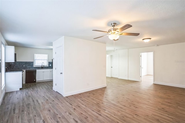 unfurnished living room with ceiling fan, sink, and light hardwood / wood-style floors