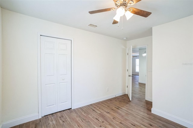 unfurnished bedroom with ceiling fan, a closet, and light hardwood / wood-style flooring