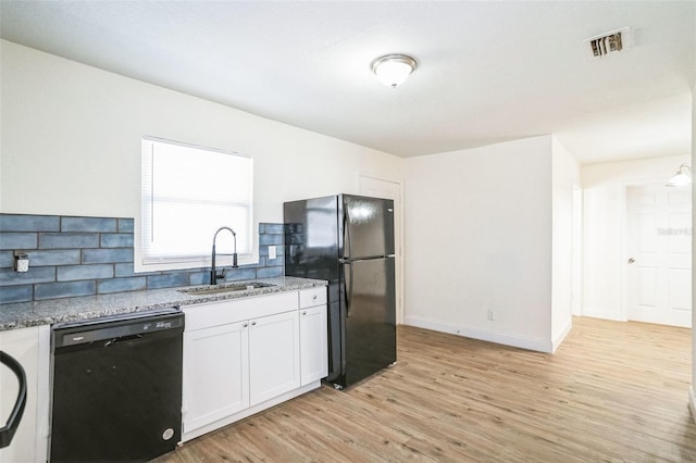 kitchen with black appliances, white cabinets, sink, light wood-type flooring, and light stone counters