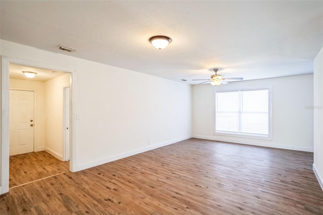 empty room featuring hardwood / wood-style floors and ceiling fan