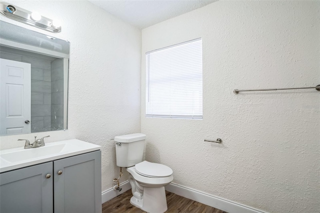 bathroom featuring wood-type flooring, vanity, and toilet