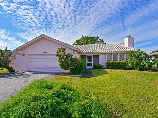 ranch-style home with a garage and a front lawn