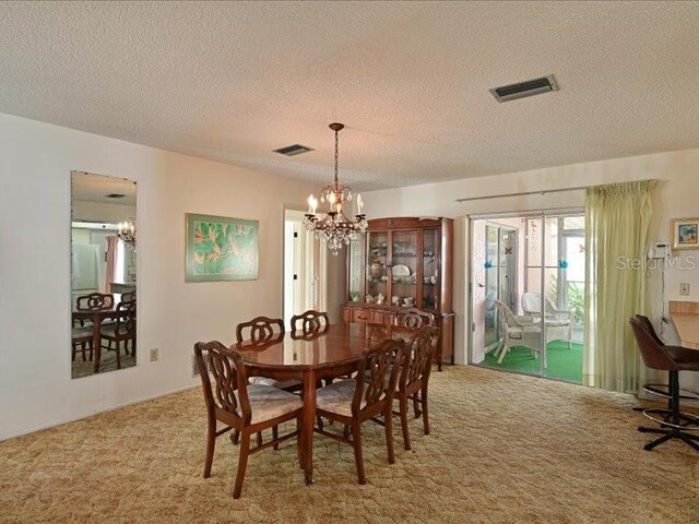 carpeted dining space featuring a textured ceiling and a notable chandelier