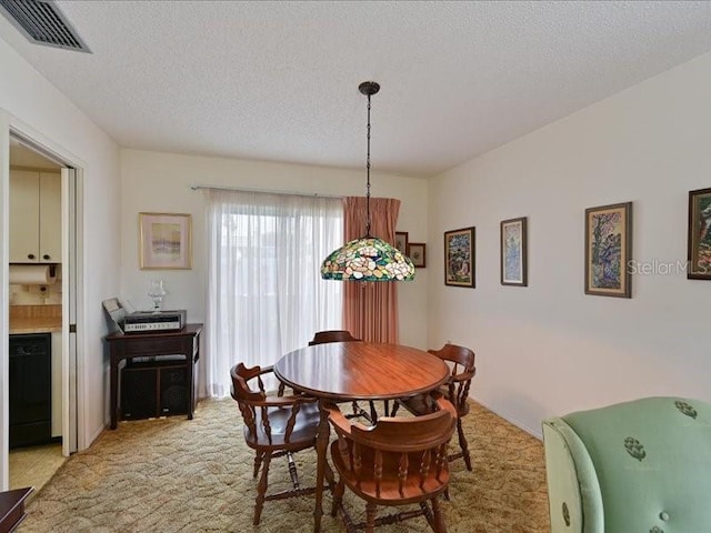 carpeted dining area featuring a textured ceiling