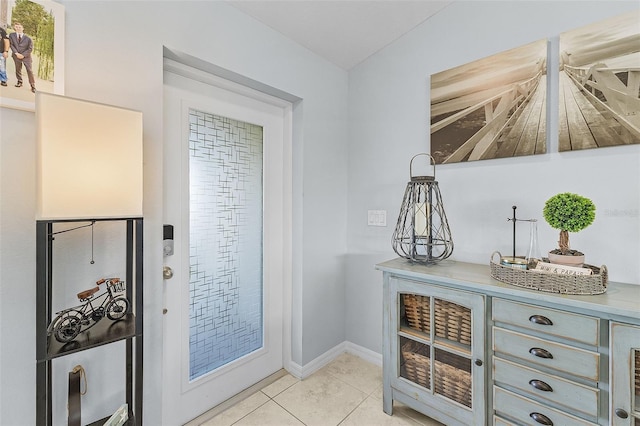 doorway to outside with light tile patterned flooring