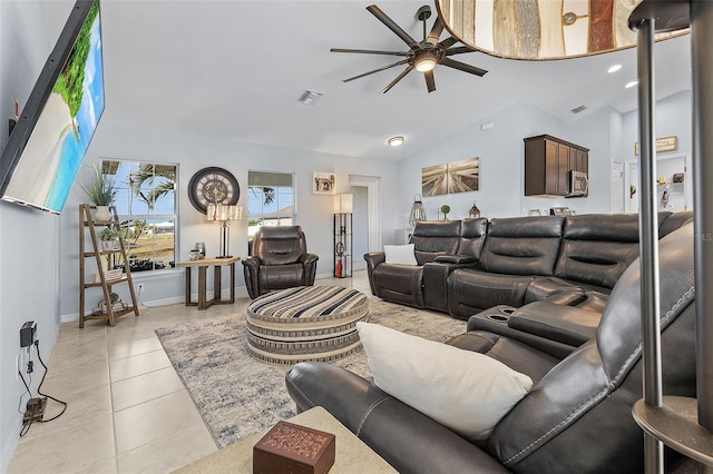 living room with ceiling fan, vaulted ceiling, and light tile patterned flooring