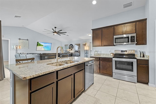 kitchen with sink, stainless steel appliances, dark brown cabinets, and lofted ceiling