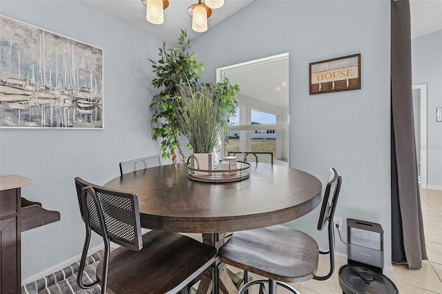 tiled dining space with an inviting chandelier and vaulted ceiling