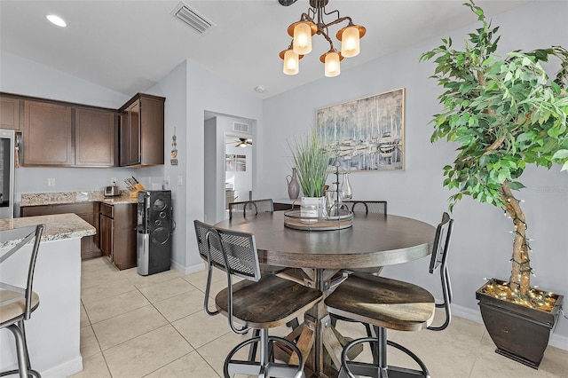 dining space with vaulted ceiling, ceiling fan with notable chandelier, and light tile patterned floors