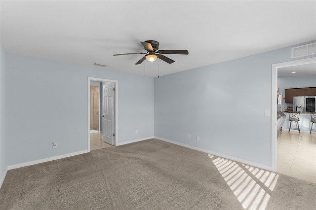 carpeted empty room featuring ceiling fan