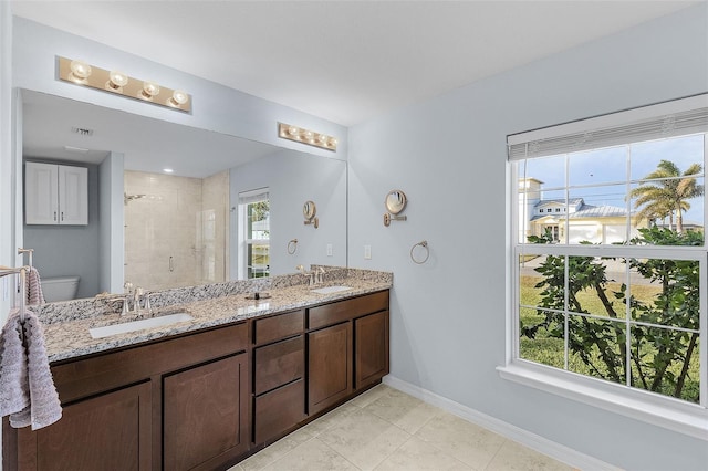 bathroom featuring a healthy amount of sunlight, a shower with door, vanity, and toilet