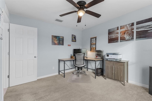 carpeted home office featuring ceiling fan