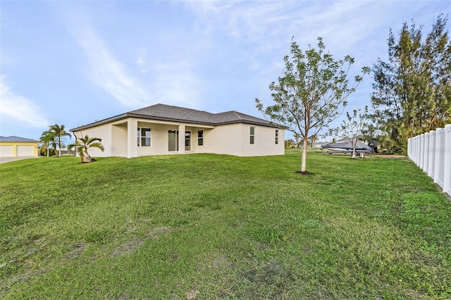 rear view of house featuring a yard