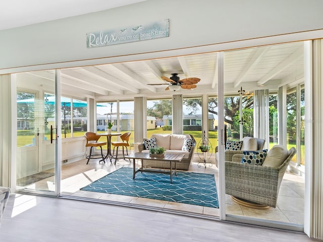 sunroom featuring beam ceiling and ceiling fan