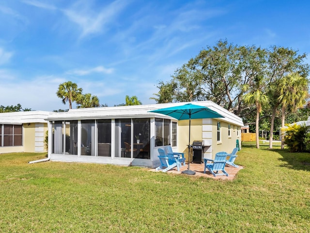 rear view of house with a sunroom and a yard