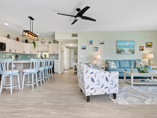 living room featuring ceiling fan and light wood-type flooring