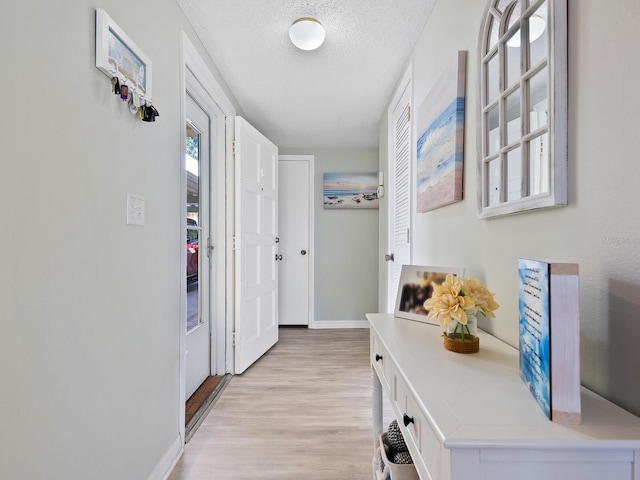 hallway featuring a textured ceiling and light wood-type flooring