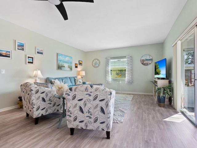 living room featuring ceiling fan and light hardwood / wood-style flooring