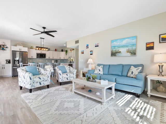 living room featuring hardwood / wood-style floors and ceiling fan