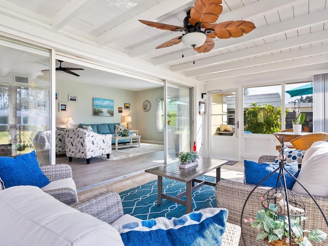 sunroom / solarium featuring beamed ceiling, ceiling fan, a healthy amount of sunlight, and wood ceiling