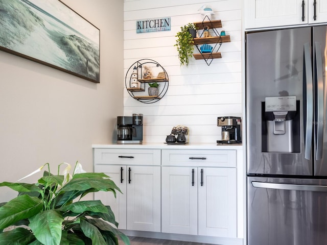 bar featuring white cabinetry and stainless steel fridge with ice dispenser