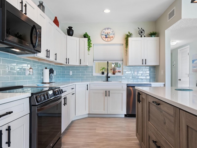 kitchen featuring white cabinetry, range with electric cooktop, sink, stainless steel dishwasher, and backsplash