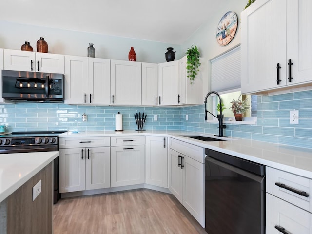 kitchen with dishwasher, backsplash, white cabinets, sink, and range