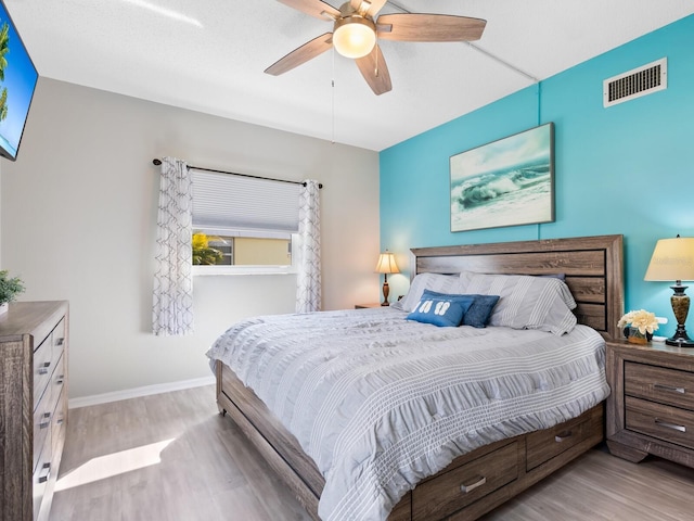 bedroom with light hardwood / wood-style floors and ceiling fan