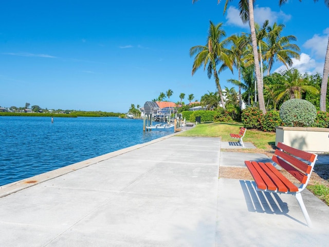 view of patio with a water view and a dock