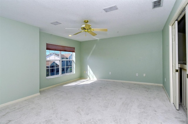 carpeted spare room with a textured ceiling and ceiling fan