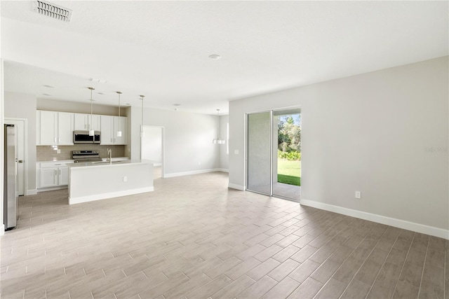 unfurnished living room featuring sink