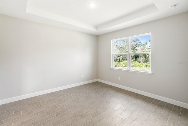 unfurnished room featuring a tray ceiling