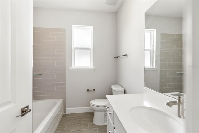 full bathroom with vanity, toilet, plenty of natural light, and tiled shower / bath combo