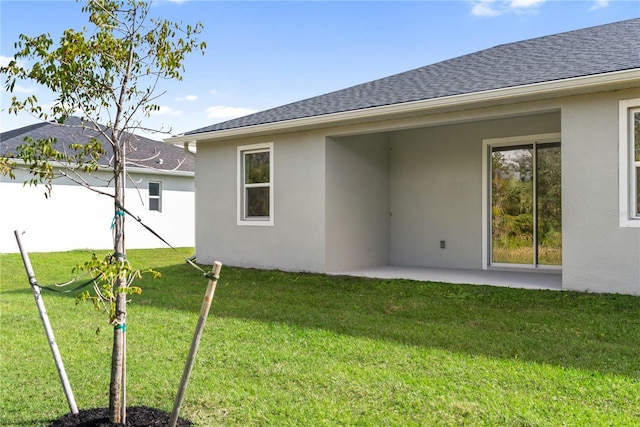 rear view of property with a lawn and a patio