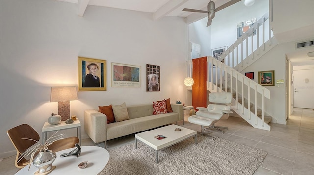 living room featuring ceiling fan, tile patterned floors, beam ceiling, and a towering ceiling