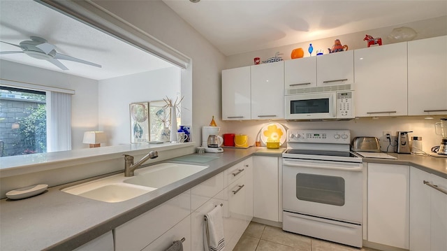 kitchen with white appliances, white cabinets, sink, ceiling fan, and light tile patterned floors