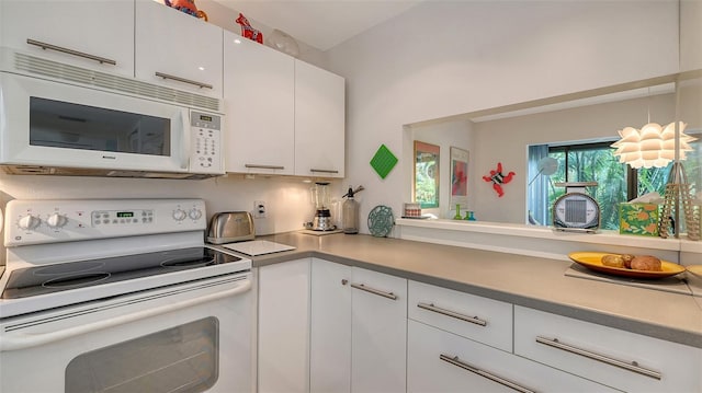 kitchen featuring white cabinets and white appliances