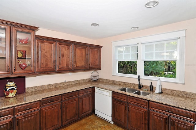 kitchen featuring light stone countertops, sink, and white dishwasher