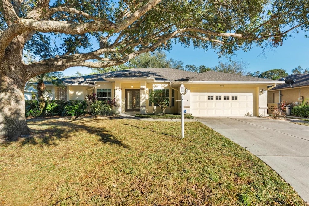 ranch-style house with a front yard and a garage