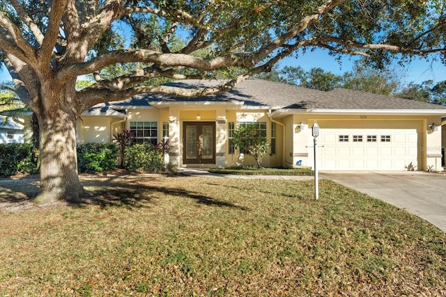 view of front of home featuring french doors, a garage, and a front lawn