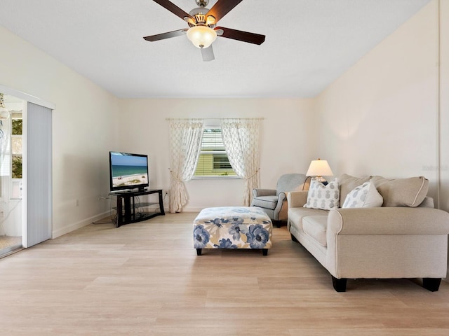 living room featuring light hardwood / wood-style flooring and ceiling fan