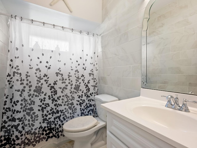 bathroom featuring vanity, curtained shower, toilet, and tile walls