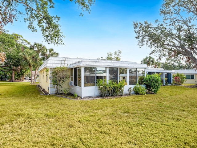 back of house featuring a sunroom and a yard