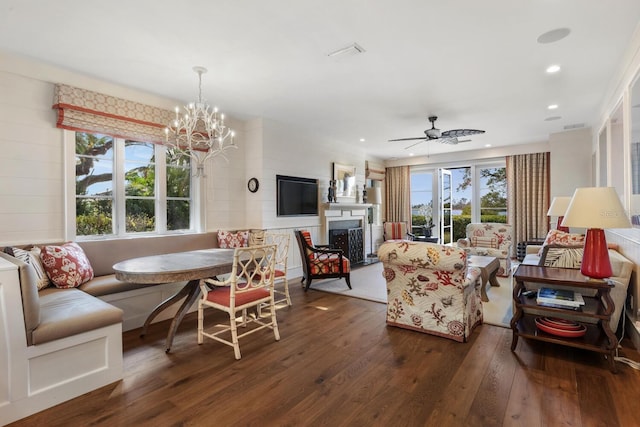 living room with ceiling fan with notable chandelier, dark hardwood / wood-style floors, and breakfast area