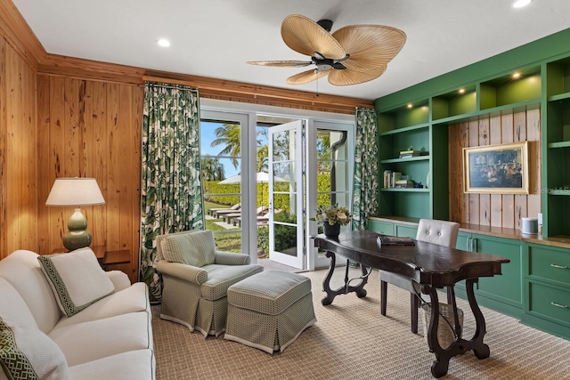 home office featuring french doors, wood walls, ceiling fan, and built in features