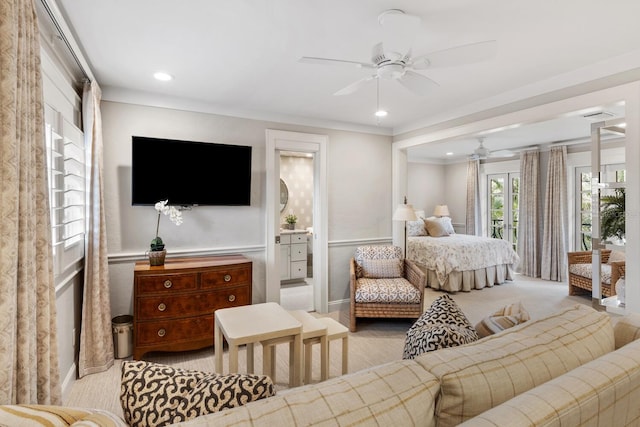 bedroom featuring ensuite bath, light colored carpet, ceiling fan, and ornamental molding