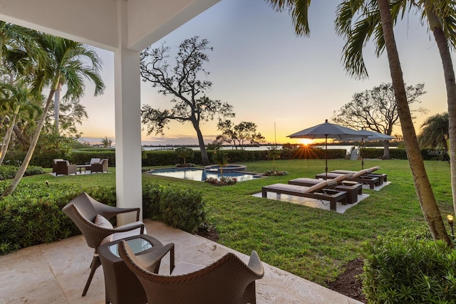 yard at dusk featuring a patio