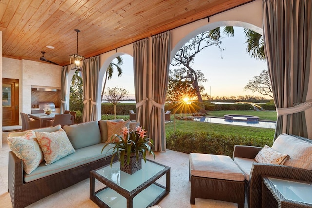 sunroom featuring a notable chandelier, wood ceiling, and a water view